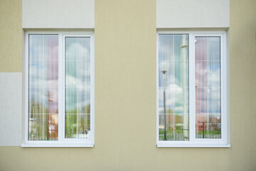Fototapeta na wymiar Two white plastic high windows with partitions