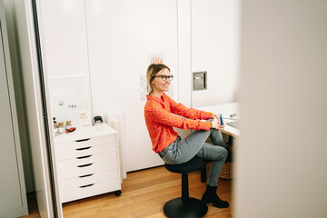 smiling business woman sits relaxed in office