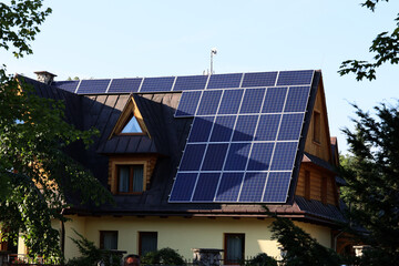Panele solarne na skośnym dachu budynku mieszkalnego. - obrazy, fototapety, plakaty