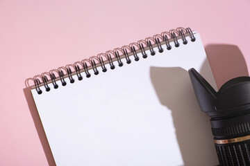 Fragment of notebook and SLR camera on desktop top view. Learning photography, blogging concept