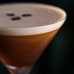 espresso martini cocktail with foam and three coffee beans