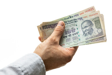 Indian rupees, bundle of money, held in hand on a light background