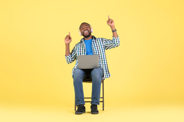 Black Guy Listening Music On Laptop Wearing Headphones, Yellow Background