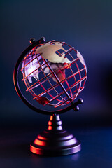 Close up metallic model of a globe with map in blue and red neon light. Bipolarity of the world....