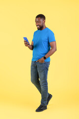 Black Guy Using Cellphone With Mobile App, Yellow Background, Vertical