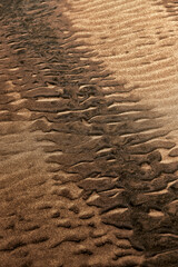 texture of sand, natural sand pattern on the beach. Sand surface with pattern, sand texture background