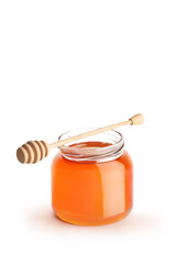 Studio shot of an open honey jar with a honey dipper