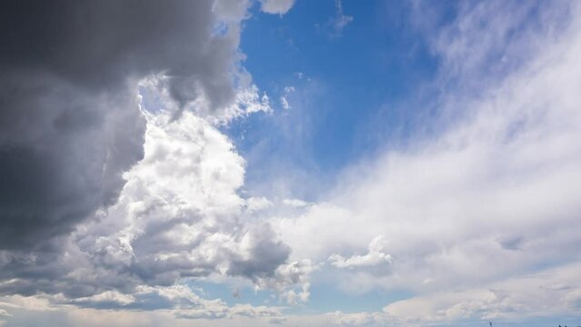 timelapse 4k b-roll of stormy cloudscape natural background. summer cloudy heavenly soft pastel blue sky. beautiful weather season in the air. dark fluffy clouds rolling in blue sky. wind blows clouds