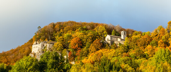 Panoramic view over "Santuario della Verna" (english name: Sanctuary of La Verna) surrounded by autumn colors. Fall foliage season. Chiusi della Verna - Casentino, Tuscany - Italy