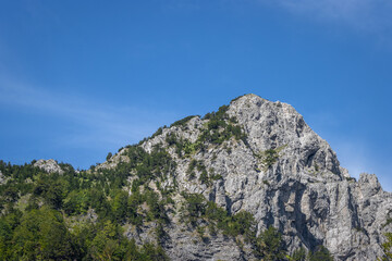 Fototapeta na wymiar stunning high grey mountain on a sunny day and blue sky, alpine area 