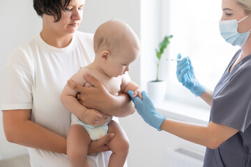 The doctor makes a baby vaccination on a white background.