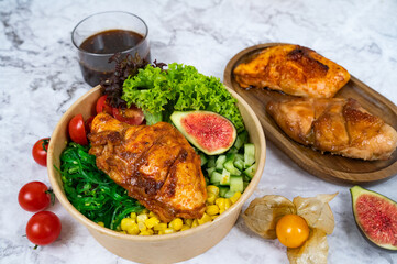 BAKED KOREAN CHICKEN BREAST with carrot, cucumber, tomato, corn and sauce served in a bowl isolated on grey background side view healthy korean food