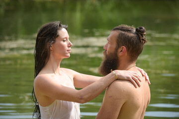 caucasian couple doing stunts in a lake