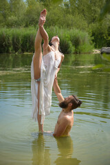 caucasian couple doing stunts in a lake