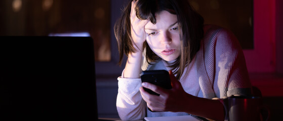 Girl works on a laptop at home at night.