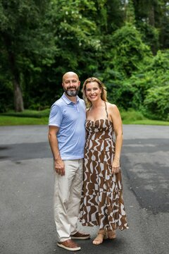 A Caucasian Couple In Their Forties Outside Looking At The Camera.