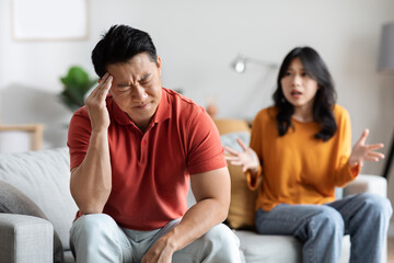 Fototapeta na wymiar Emotional asian spouses having fight at home