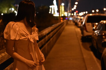 a woman going out at night Turn to look at the twinkling lights. If there is a bokeh behind the...