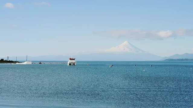 Boat floating in front of volcano in puerto varas chile