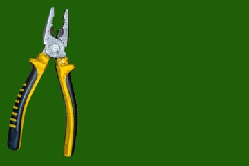 Modern and beautiful pliers on a green background