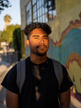 Native student with a serious face poses outside of school for a vertical portrait