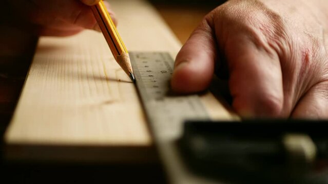 Carpenter using square to measure on wooden background