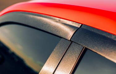 A red car showing the top of the door