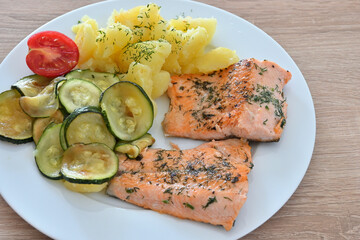 Pieces of fried trout with zucchini and potatoes