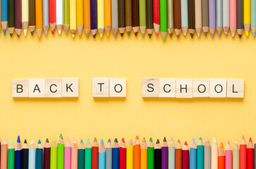 Obraz premium Back to class. Coloured pencils and letters BACK TO SCHOOL on yellow background. Copy space.