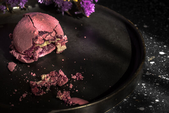 Violet flowers and macaroons on table