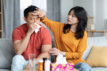 Young wife taking care of sick husband at home