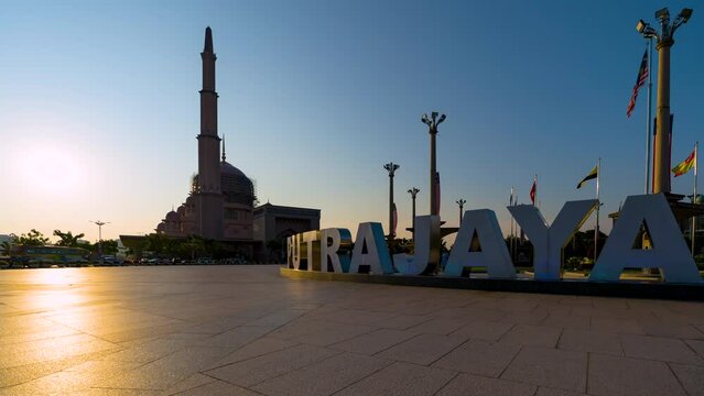 Low Angle Dramatic Sunset Time Lapse at Putra Mosque with The colorful Putrajaya sign, Putrajaya, Malaysia.