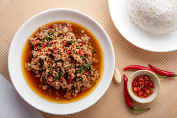 Rice topped with stir-fried pork and basil. Stir fried basil. on wooden table background. top ten...
