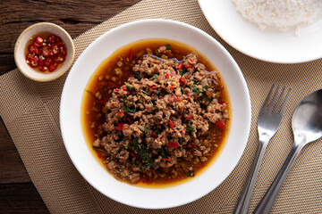 Rice topped with stir-fried pork and basil. Stir fried basil. on wooden table background. top ten thaifood menu