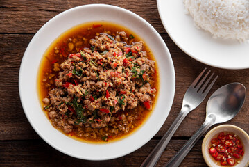 Rice topped with stir-fried pork and basil. Stir fried basil. on wooden table background. top ten thaifood menu