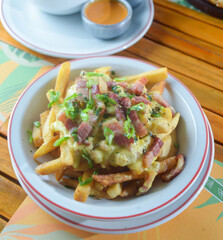 Dish of French fries with cheddar and bacon