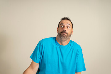 I don't know, who cares. Portrait of confused and clueless dark-haired man with beard and blue...