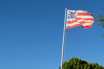 The flag of the former Dutch village Smilde in Drenthe bird and stripes banner fluttering in blue sky