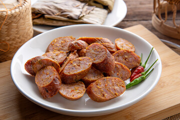 Thai sausage or sai oua. Northern Thai food menu over plate on wooden table background. thaifood concept