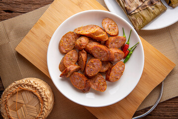 Thai sausage or sai oua. Northern Thai food menu over plate on wooden table background. thaifood concept