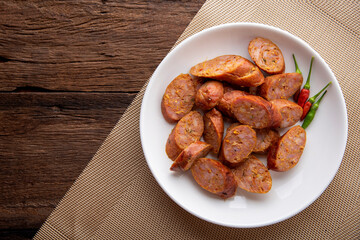 Thai sausage or sai oua. Northern Thai food menu over plate on wooden table background. thaifood concept