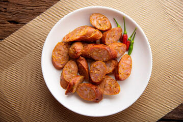 Thai sausage or sai oua. Northern Thai food menu over plate on wooden table background. thaifood concept