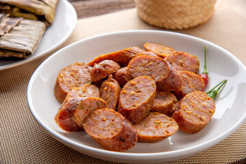 Thai sausage or sai oua. Northern Thai food menu over plate on wooden table background. thaifood concept