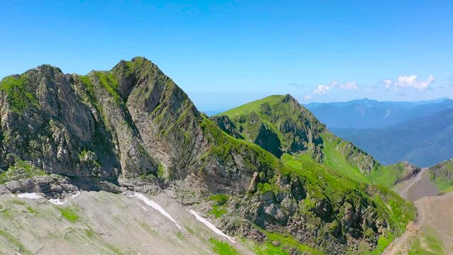 Majestic aerial view of the top of the mountain range and mountain cirque valley with shady snow slopes