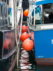 Fishing boats with prepared nets and buoys anchored in the port