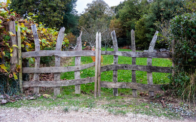 wooden slat fence weathered by the passage of time in a green field