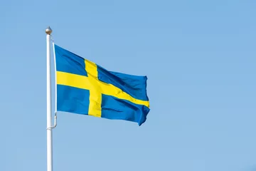 Fotobehang swedish flag on blue sky © Johannes Jensås