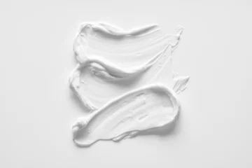 Fotobehang White smear of cosmetic cream or acrylic paint isolated on white background. © Artem Mykhailichenko