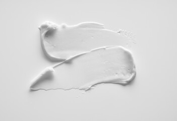 White smear of cosmetic cream or acrylic paint isolated on white background.