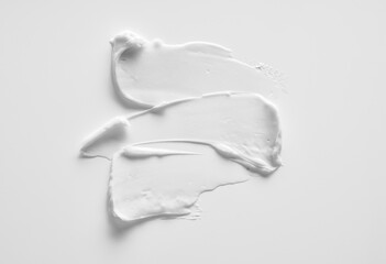 White smear of cosmetic cream or acrylic paint isolated on white background.